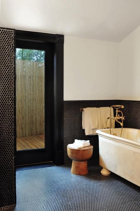 black penny tiles on the floor and walls create stylish decor