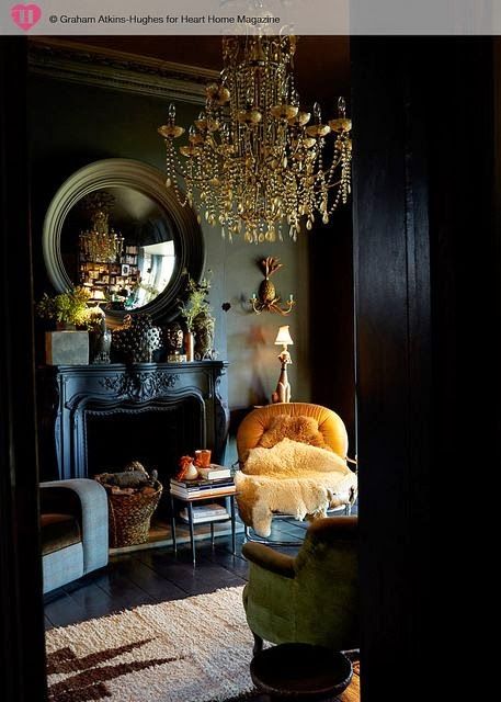 elegant neoclassic living room with black walls, an antique fireplace and a gold chandelier