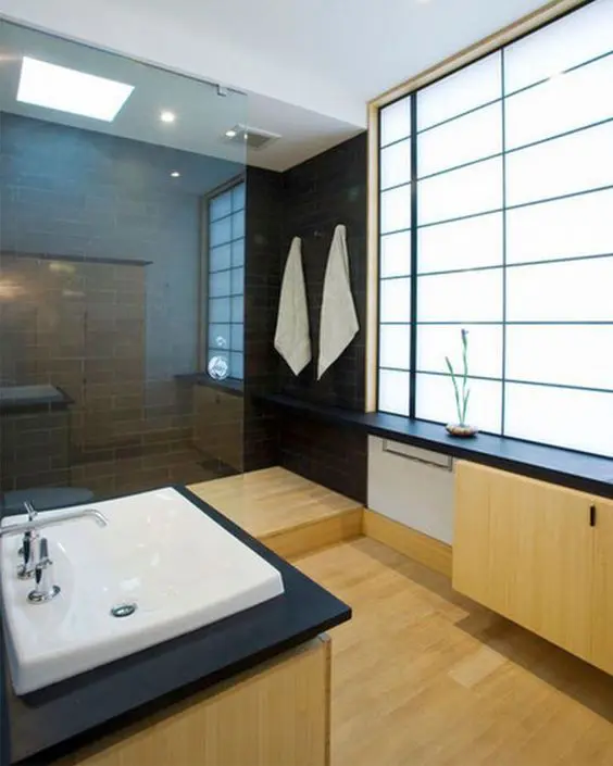 minimalist Japanese bathroom with black tiles and light woods