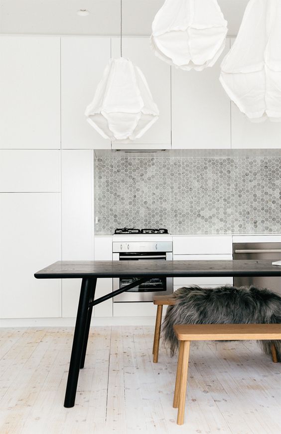 minimalist white kitchen is spruced up with grey tiles of various tones