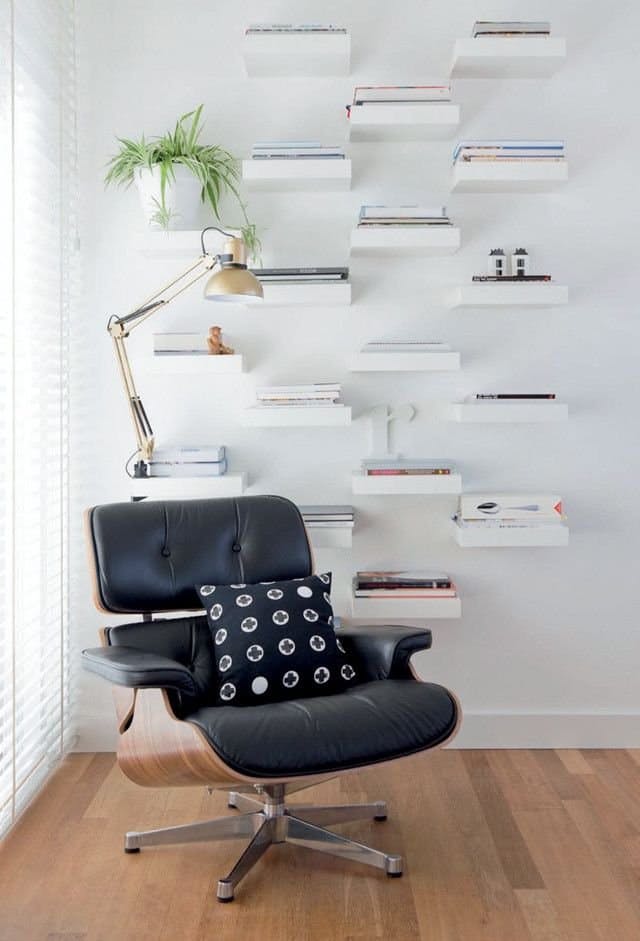 a wall of little shelves that creates a library in the living room