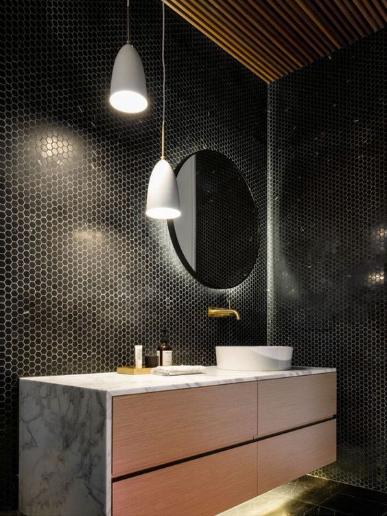 as black tiles are rather dark, hidden lights make the bathroom more welcoming