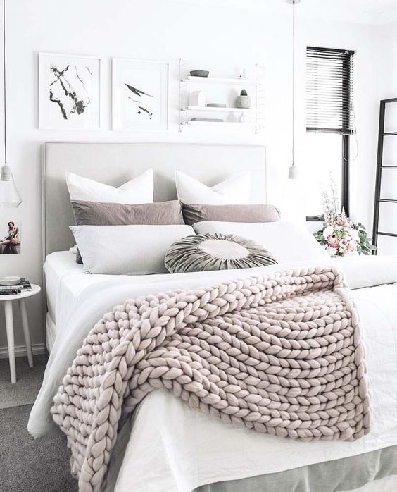 a chunky knit wool throw adds texture and interest to this neutral bedroom