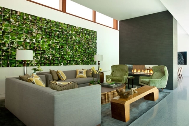 grey living room is spruced up with green chair and a striking wall mural