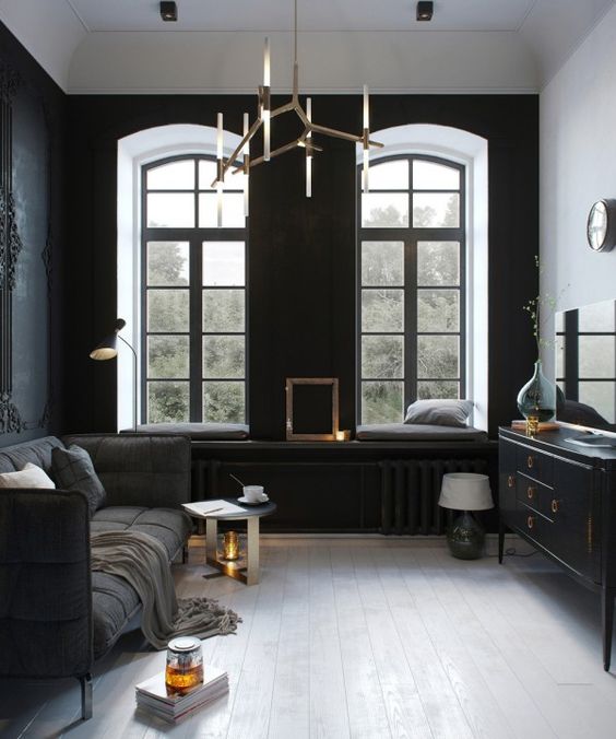 small dark sitting room, chic modern furniture and a unique brass chandelier
