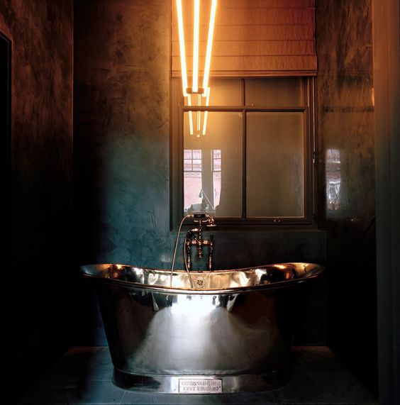 industrial space with a metallic bathtub for a masculine bathroom