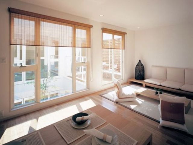 modern Japanese living and dining space with large windows and mabmboo shades