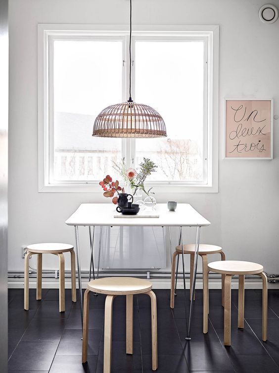 simple dining room with Ikea Frosta stools and a basket lamp
