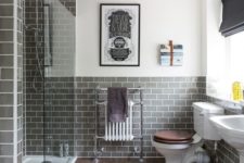 grey subway tiles for the shower and the bathroom backsplash paired with stained floor and some art create a unique and bold look