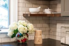 black kitchen countertops crisply contrast a white subway tile backsplash for a look that’s fresh and simple