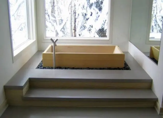 minimalist soaking bathtub placed in black pebbles with a cool view will make relaxation full