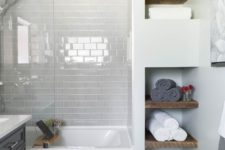 a small bathroom with very light grey subway tiles that make white details stand out and create a peaceful mood