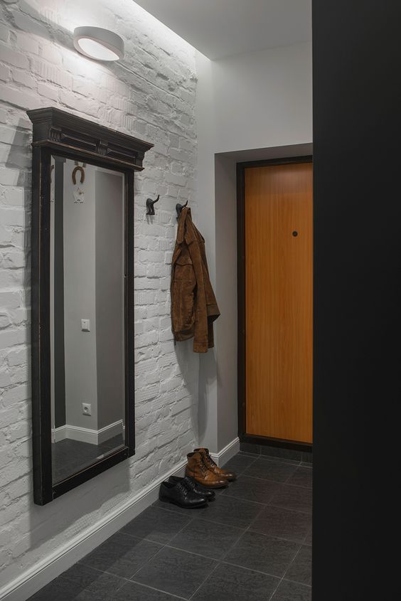 laconic bachelor entryway with a white brick wall