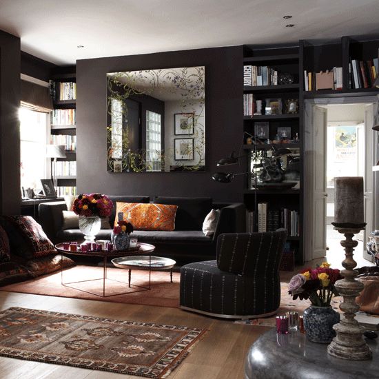 dark living room with black walls, colorful accessories and various textiles