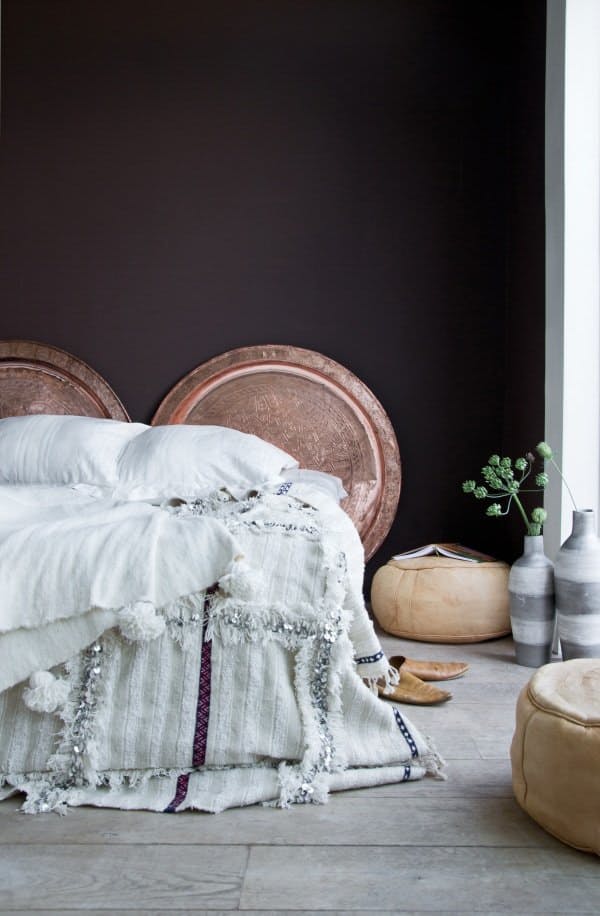 soft bedding and copper dishes instead of headboards in an Eastern room