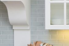 subway tiles in a pale blue-gray give depth to the backsplash and make the white cabinetry feel even more fresh