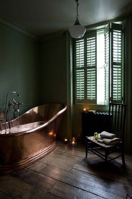 vintage bathroom with a copper bathtub and green walls