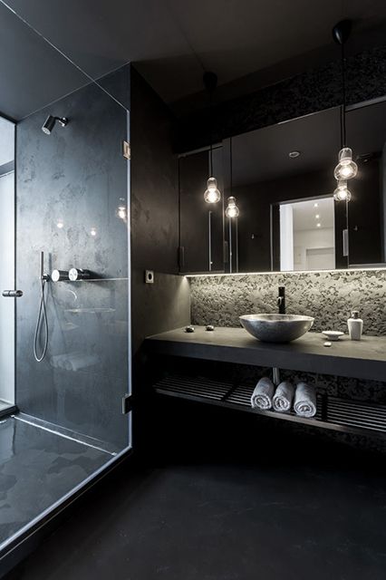 black modern bathroom with a concrete countertop and a tiled shower