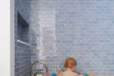 unusual watery blue subway tiles and a terrazzo covered bath look so contrasting and cool together and make your bathing space unique