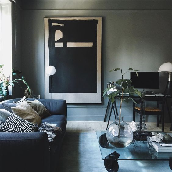 grey walls, a navy sofa and a modern large scale artwork