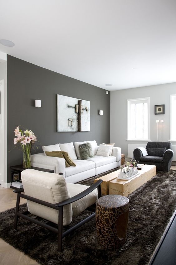 dark grey accent wall and light grey other walls, neutral furniture