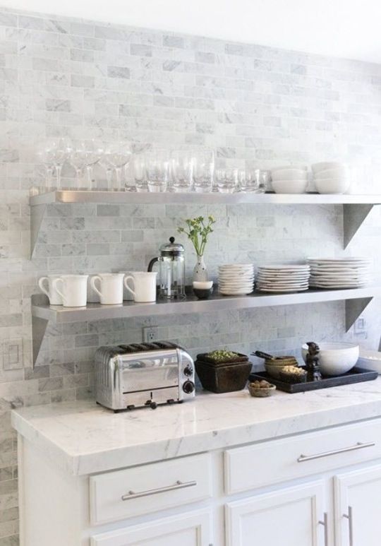 White farmhouse cabinets with white stone countertops and marble looking subway tiles for delicate and subtle decor