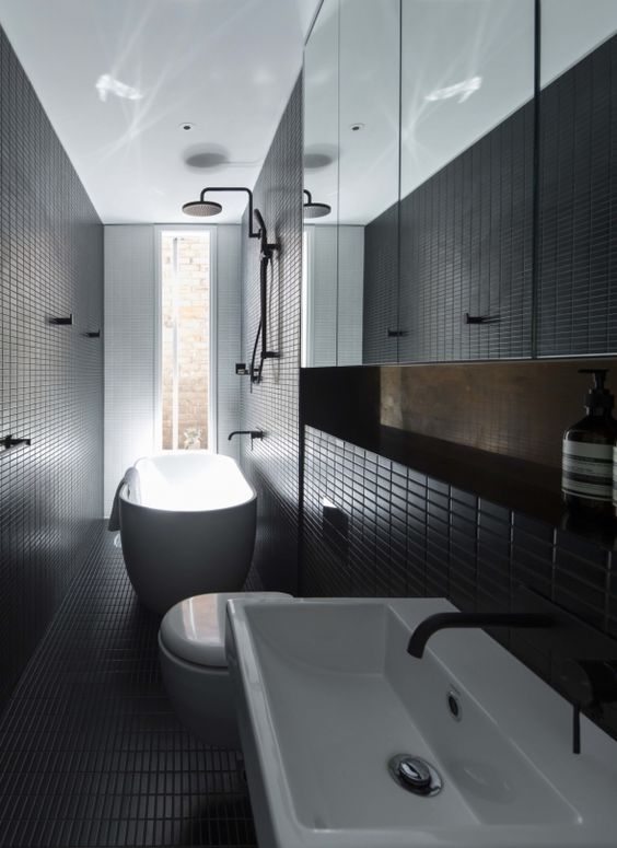 Modern black bathroom clad with small tiles that add the space eye catchy