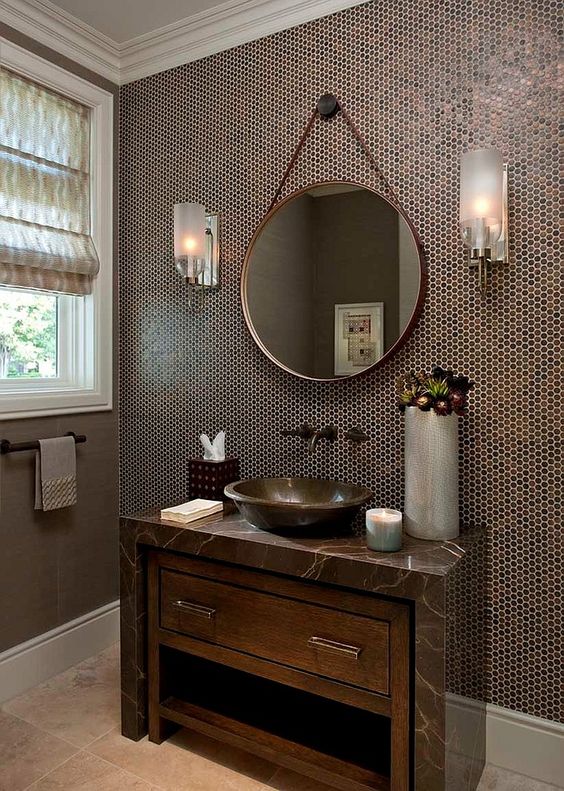 penny tiles in the shades of brown highlights the sink and a marble counter