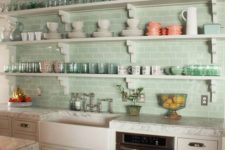 aqua-colored subway tiles covering the whole wall infuse the kitchen with color and substitute upper cabinets
