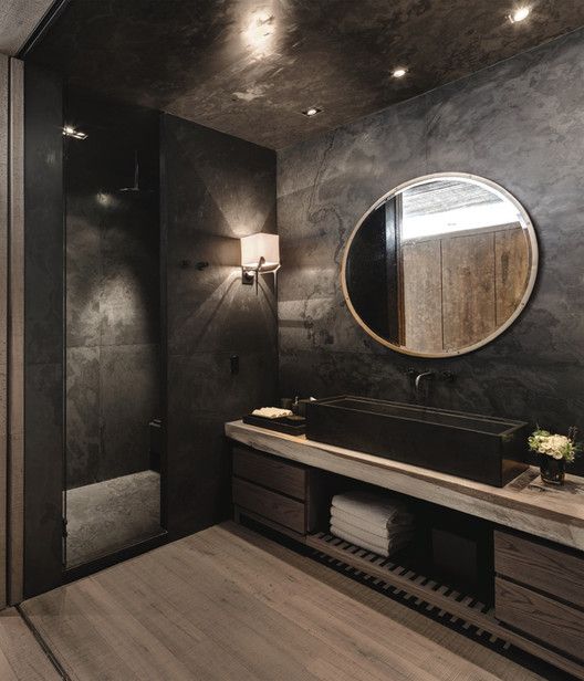 moody bathroom with a huge sink, wooden floor and cabinets