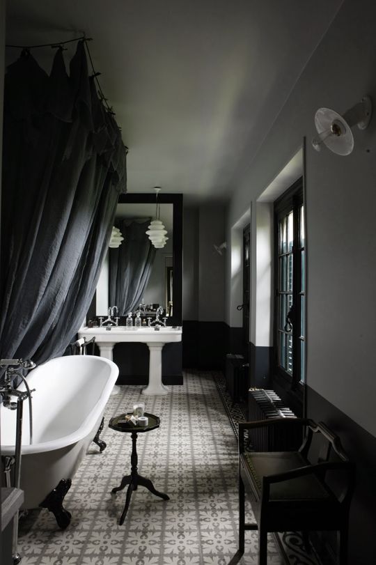 moody vintage bathroom with white sinks and a bathtub, vintage furniture makes up the space