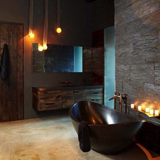 sexy masculine bathroom with a dark bathtub, dark tiles and wooden cabinets