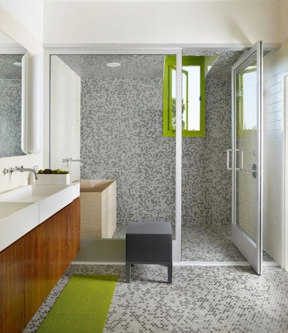 grey tiles on the walls, floor and in the shower contrast with lime green accents