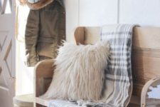 38 simple farmhouse entryway is perfectly decorated for winter with large coat hooks, a rustic bench, and a place for snow-covered boots