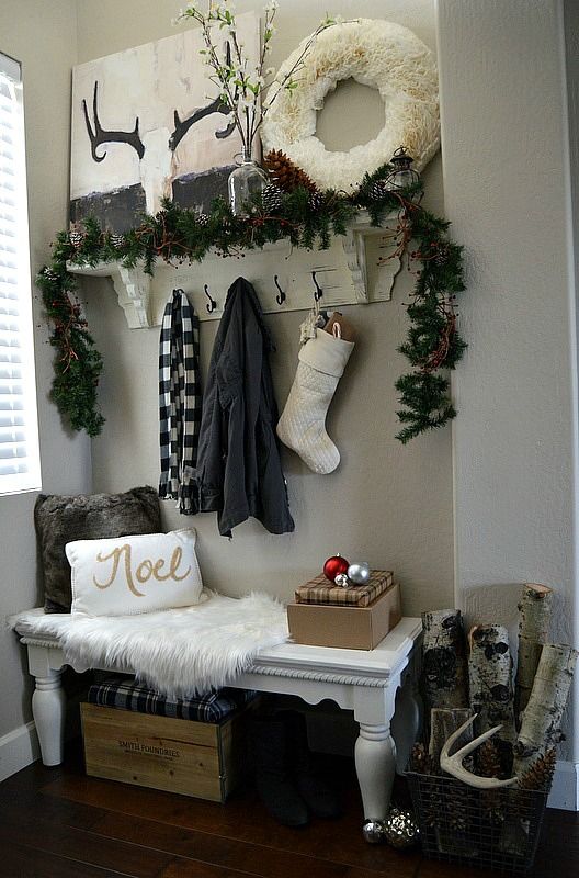 white tissue paper wreath, a fir garland, a couple of ornaments and logs give this entryway a wintry look