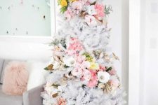 a delicate white Christmas tree with pink, white and yellow florals covering it in a swirl, with pale greenery is an out of the box idea