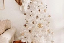 a glam white Christmas tree with gold ornaments and snowflakes looks very chic, beautiful and elegant