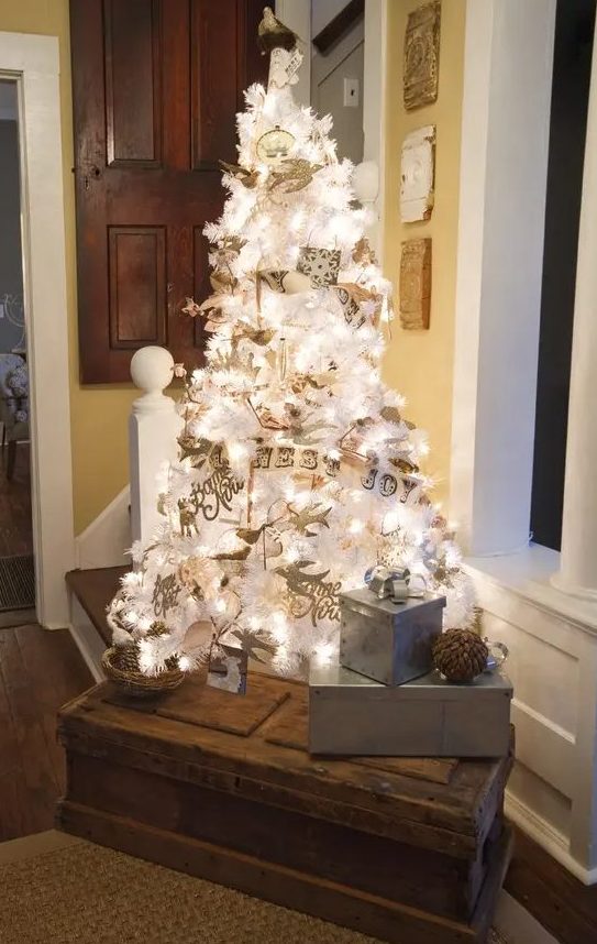 a lovely white vintage Christmas tree with lights and silver and white Christmas ornaments plus banners and calligraphy is wow