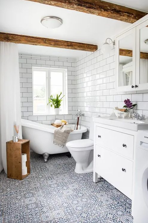 a modern farmhouse bathroom with white subway, blue mosaic tiles, a white vanity, a mirror cabinet and a clawfoot tub