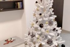 a modern white Christmas tree with gold and black ornaments is a catchy and bold modern solution