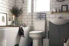 a monochromatic bathroom with a hex tile floor, subway tiles on the walls, a tub, candles and some cute decor