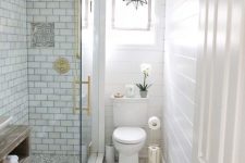 a neutral small bathroom with beadboard, printed tiles, subway tiles in the shower, gold touches and a star-shaped chandelier