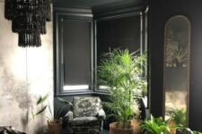 a refined black bedroom with a bay window, a black beaded chandelier, potted plants, faux fur and an arched mirror