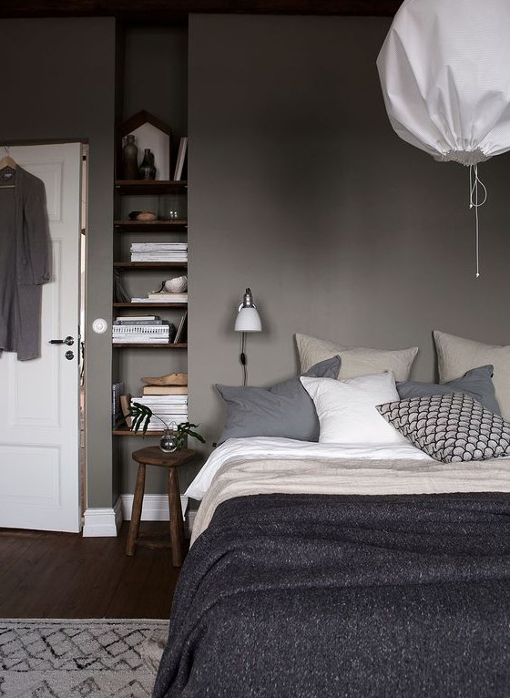 a relaxing grey bedroom - grey walls, dark stained furniture, grey and white bedding create a moody yet peaceful place to be