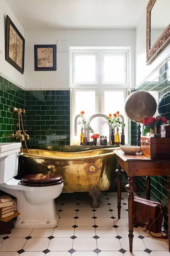 a small vintage bathroom with green subway tiles, a vintage stained vanity, artwork and a mirror, blooms and some decor