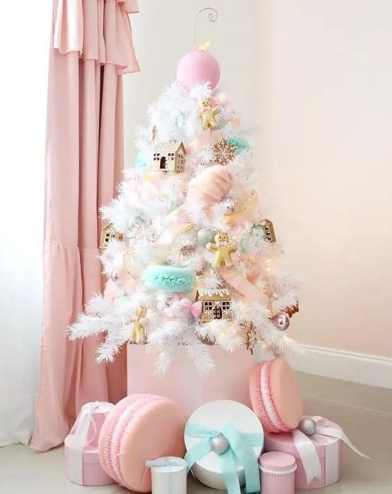 A small white Christmas tree decorated with pink, aqua, blush ornaments   houses, cookies, macarons and oversized ornaments looks amazing