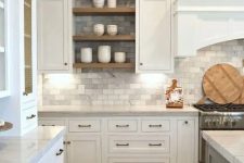 a traditional white kitchen with grey marble subway tiles on the backsplash and walls plus wooden touches