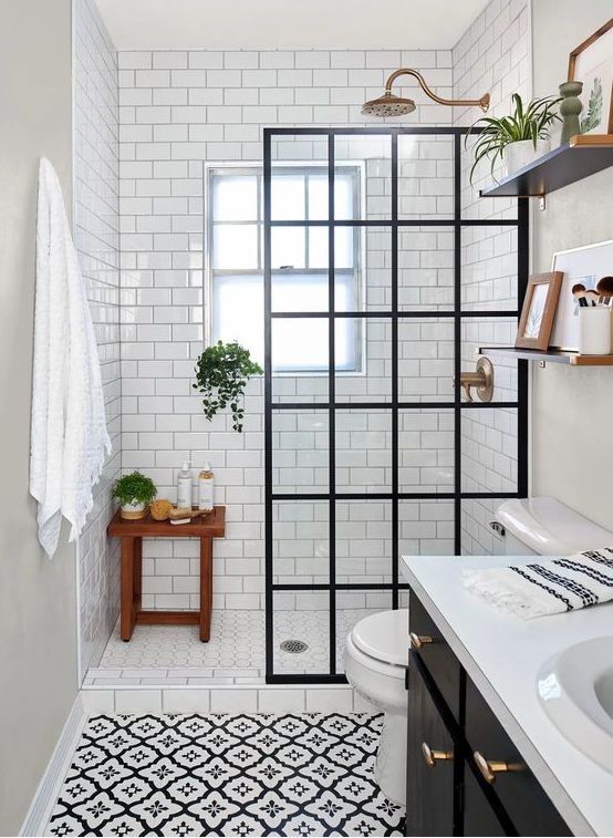A vintage inspired bathroom with white subway tiles and printed ones, a shower space with a screen, a black vanity and shelves