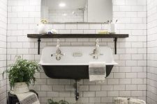 a vintage-inspired powder room in black and white, with white subway tiles with black grout
