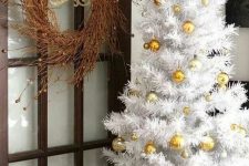 a white Christmas tree decorated with gold ornaments is a glam and chic idea for a Christmas space with gold touches
